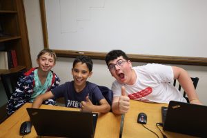 Three kids at 6 Points Sci-Tech smiling with thumbs up